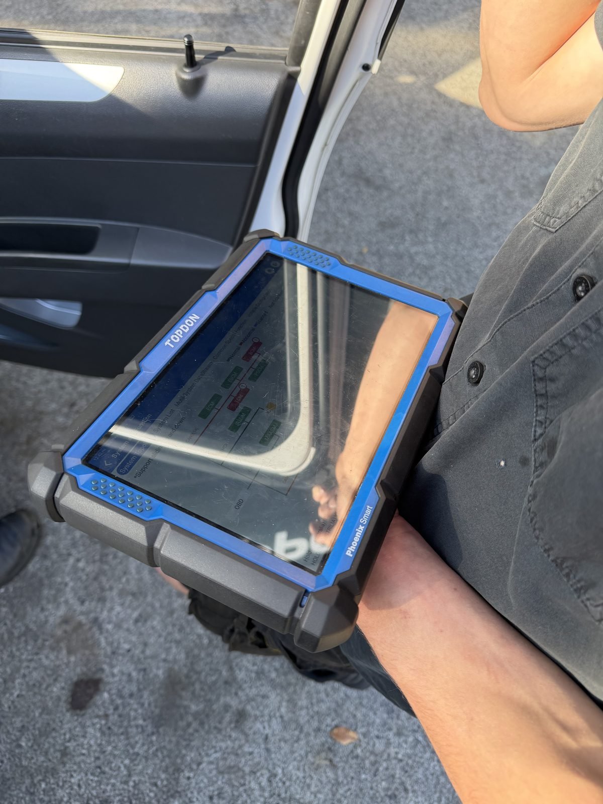 TOPDON dealer-level diagnostic scan tool in use at a vehicle